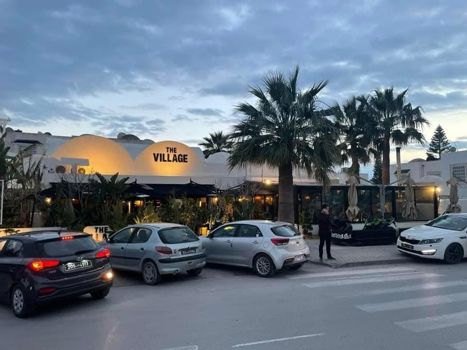 The terrace and palm trees from the street at dusk