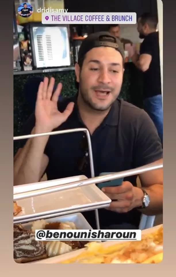 Instagram story tagged at The Village: a guest waving at the camera over a brunch tray