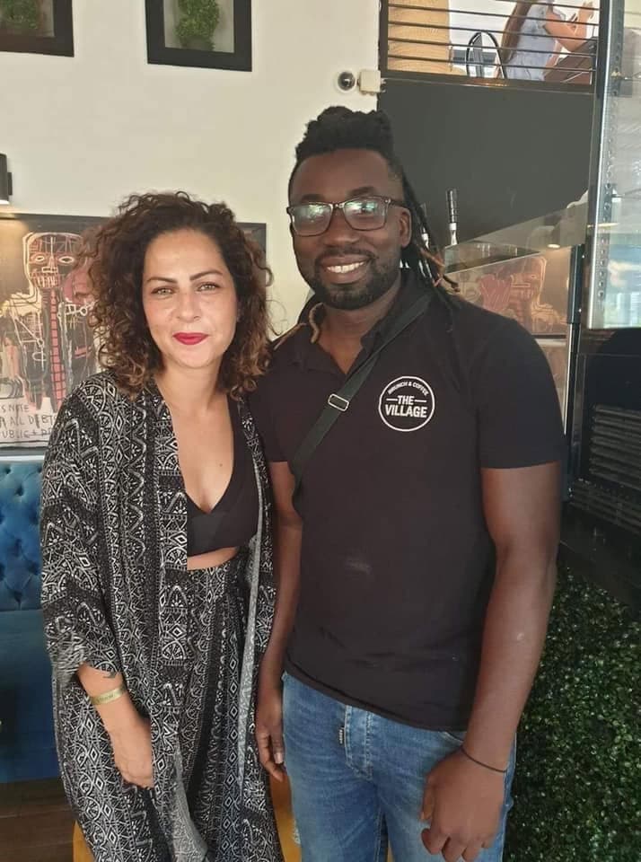 A guest photographed with a member of the team, inside the room